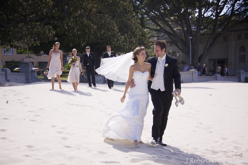 Bridal party walking along beach - wedding photography